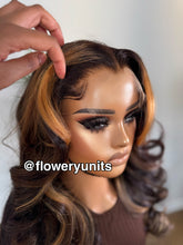 Load image into Gallery viewer, Image of a mannequin head with a glueless closure brown wig featuring honey blonde highlights. The wig is lightly layered and styled in cascading curls. The wig has curtain bangs and face framing layers.
